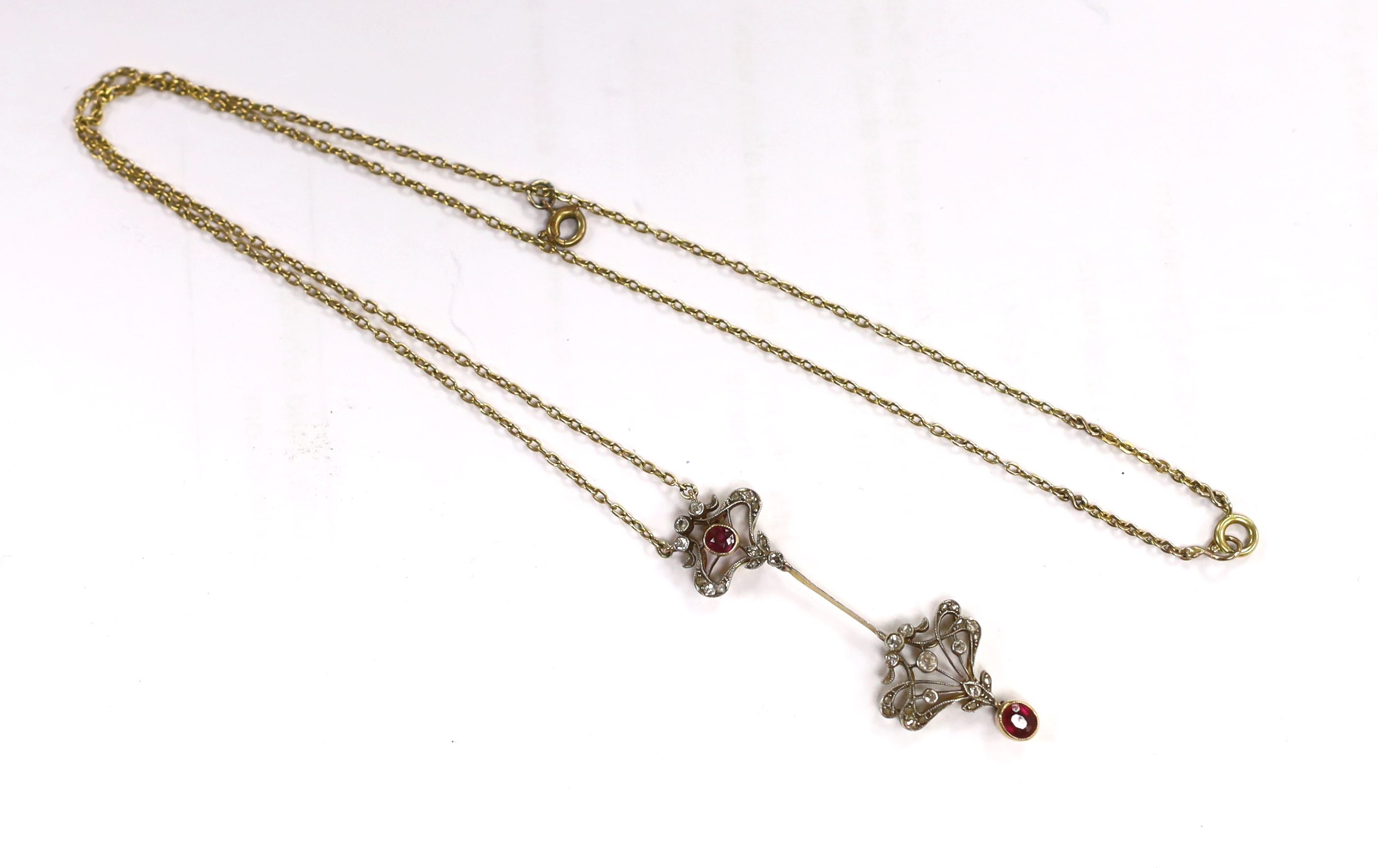A Belle Epoque yellow metal and millegrain set ruby and diamond drop pendant necklace, the chain bale stamped 9ct, pendant 46mm, chain 47cm, gross weight 5.4 grams.